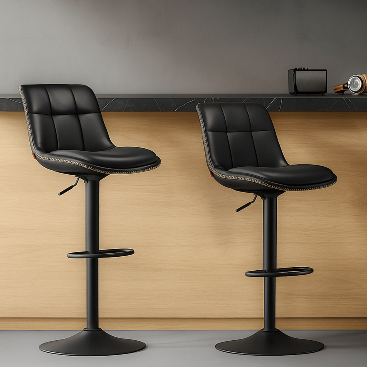 Deux chaises de bar noires en cuir avec pied noir dans une cuisine moderne