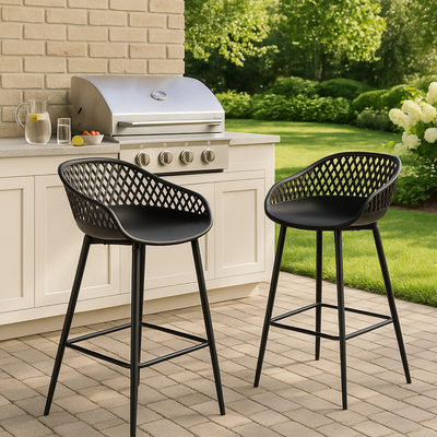 Deux chaises de bar noires ajourées en plastique sur terrasse extérieure