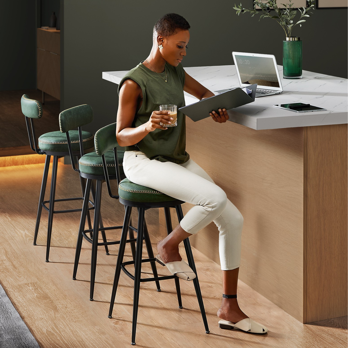 Chaises de bar vert foncé en cuir utilisées autour d’un comptoir moderne