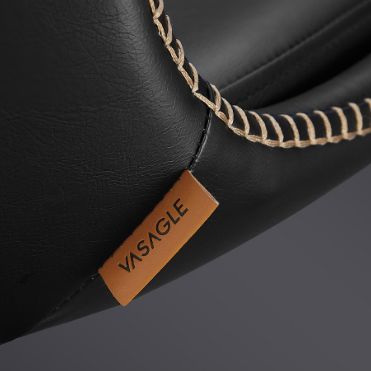 Détail de la couture contrastée sur le cuir d’une chaise de bar noire